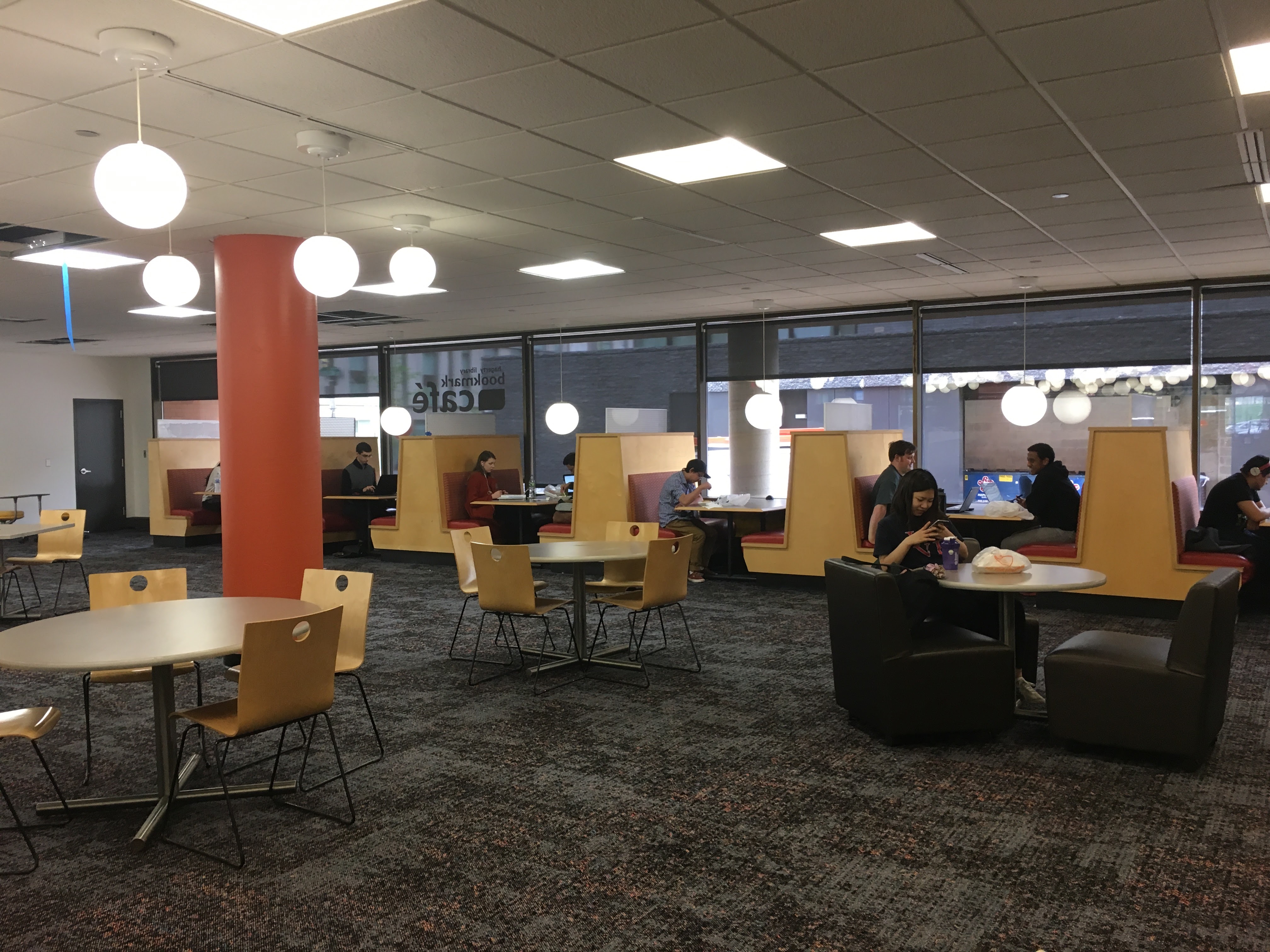 A female student sits at a table in the Bookmark Cafe. 